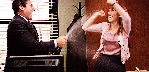 Gif de uma cena da série The Office, com duas pessoas estourando chapanhe, representando um coworking