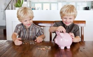 Duas crianças poupando dinheiro, representando educação financeira