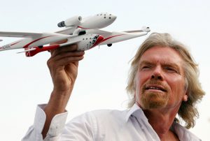 Foto do empresário Richard Branson segurando um protótipo de avião