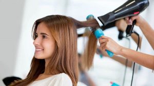 Mulher secando o cabelo de outra em salão de beleza, representando uma das tendências de franquias