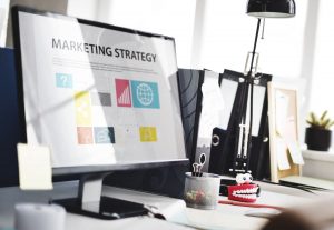 Foto de um computador com a escrita na tela "estratégia de marketing", representando os 8ps do marketing digital
