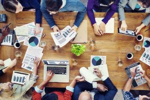 Foto de muitas pessoas sentadas à uma mesa, discutindo o marketing contábil