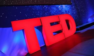 Foto do palco com o logo principal das palestras do TED