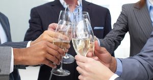 Foto de alguns empresários fazendo um brinde com champanhe, representando o início de 2018 sem dívidas