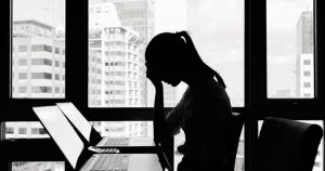 Foto de uma mulher olhando o notebook e em pose de preocupação, representando o fracasso do negócio