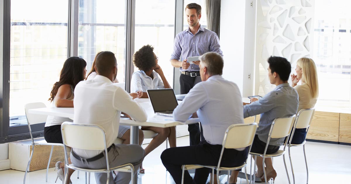 Foto de uma equipe reunida em uma mesa, representando a gestão da equipe de vendas