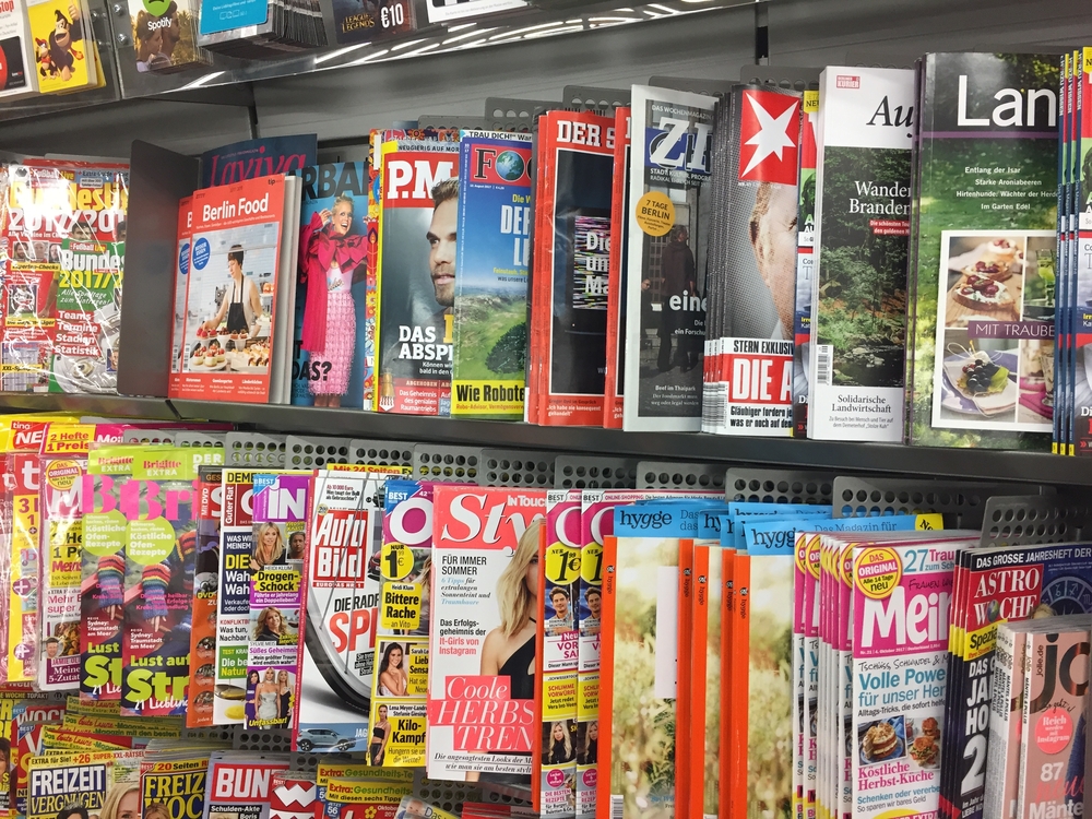 Foto de algumas revistas em uma prateleira, representando como abrir uma banca de revista