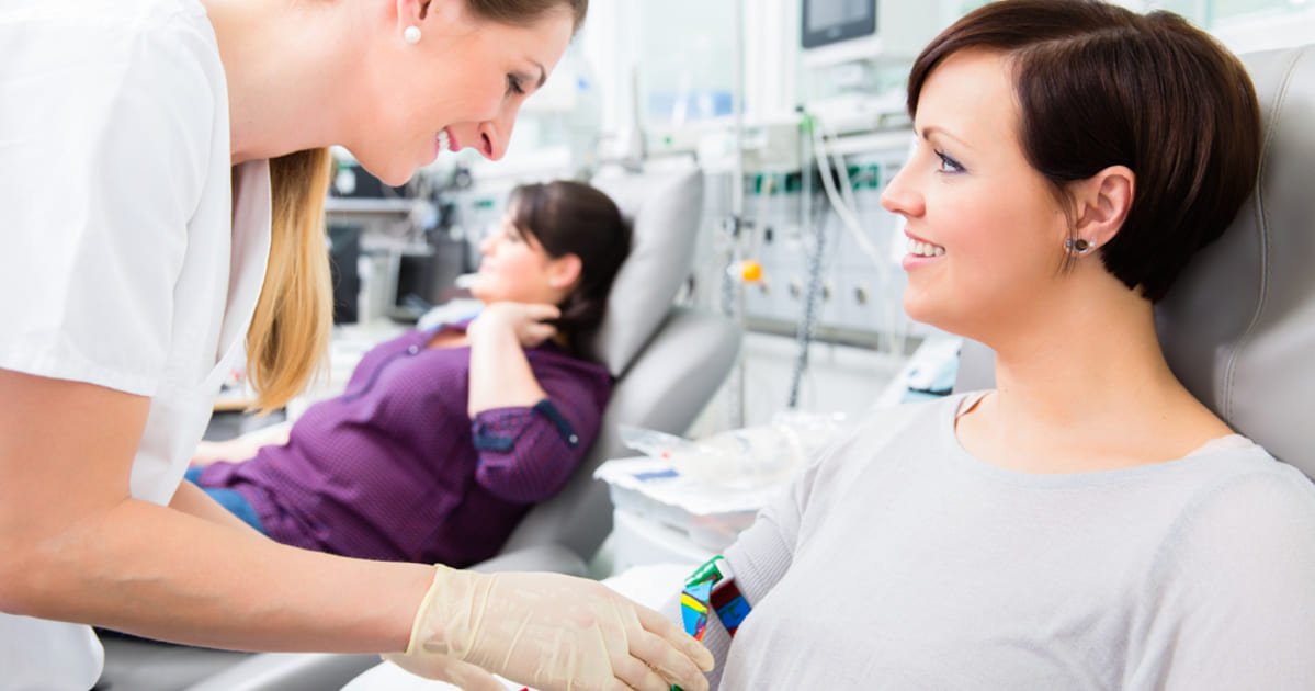 Foto de uma enfermeira e uma paciente sorrindo, representando como abrir uma clínica de saúde