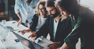 foto de várias pessoas analisando um notebook, representando como empreender em Manaus