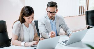 Foto de um casal conversando e mexendo no computador, representando como empreender em niterói