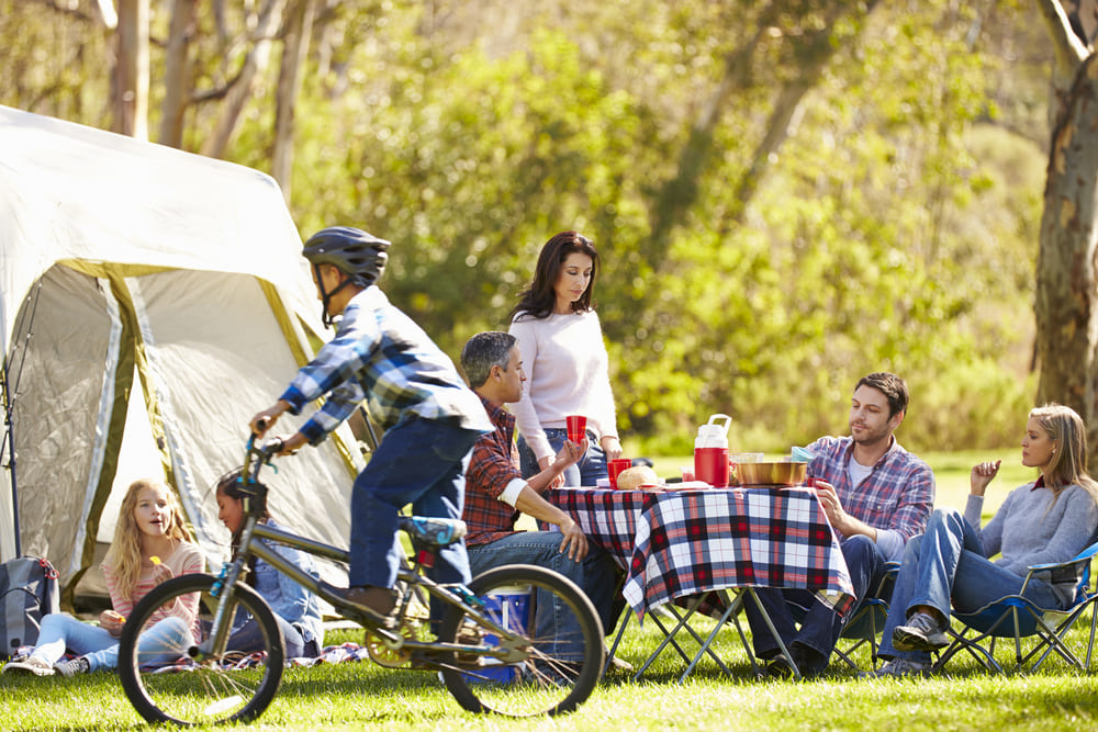 foto de uma família reunida e um menino andando de bicicleta, representando como montar um camping