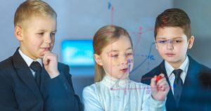 foto de três crianças, com roupas sociais e anotando um grafico, representando o empreendedorismo nas escolas