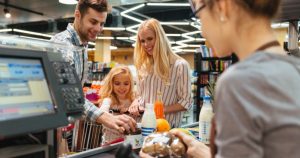 foto de dois adultos e uma criança fazendo compras, representando como abrir uma loja de conveniência