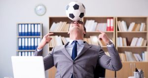 foto de um empresário no escritório com uma bola de futebol, representando o endomarketing para a copa
