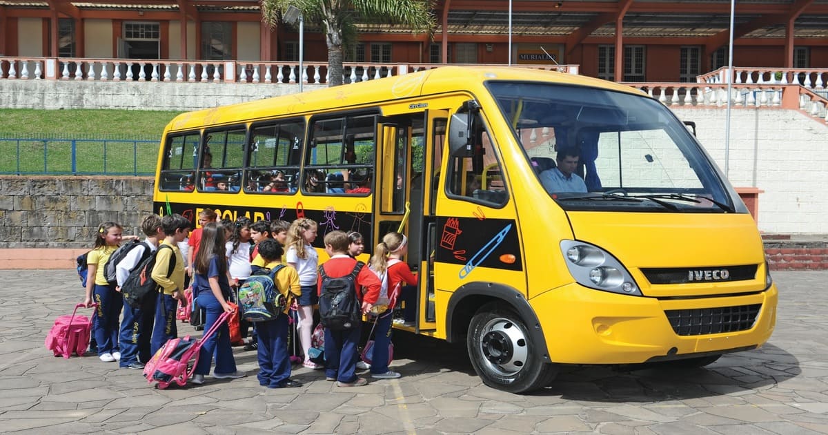 Crianças entrando no veículo, representando como trabalhar com transporte escolar