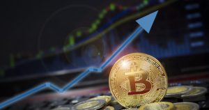 foto de uma moeda virtual em frente um gráfico crescente, representando as previsões do Bitcoin