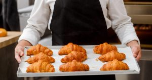 Imagem de uma assadeira cheia de croissant para inspirar os empresários que desejam abrir uma croissanteria