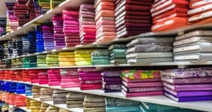Imagem de algumas prateleiras com tecidos para remeter ao empreendedor que vai abrir uma loja de tecidos